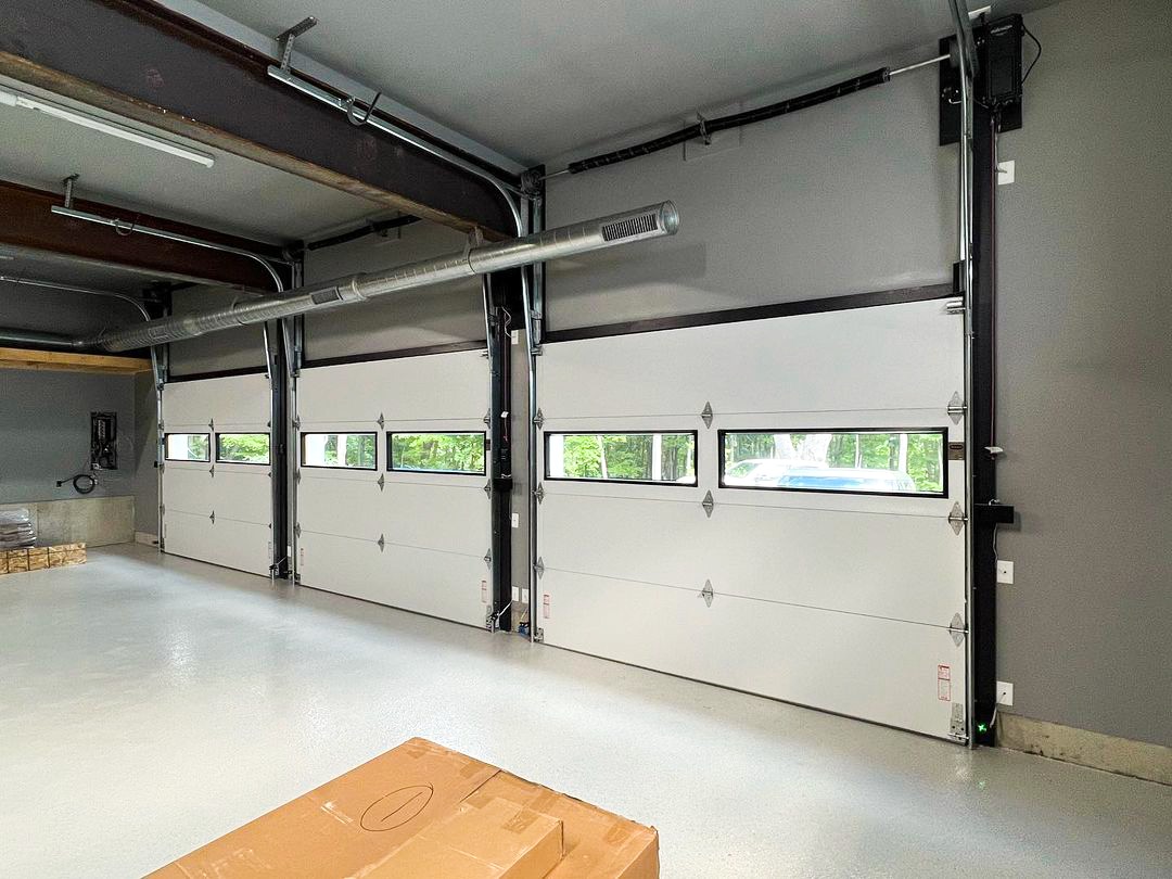 Indoor view of a triple commercial garage door with windows